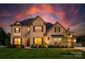 Stunning two-story brick home featuring a well-manicured lawn and beautiful landscaping at 5051 Hyannis Ct, Matthews, NC 28104