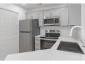 Updated kitchen features stainless steel appliances, gray cabinets with gold pulls, and granite countertops at 6523 Clavell Ln, Charlotte, NC 28210