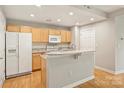 Bright kitchen featuring stainless steel appliances, light wood cabinets, and breakfast bar at 718 W Trade St # 708, Charlotte, NC 28202