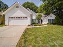 Inviting one-story home with lush lawn, a two-car garage, and manicured landscaping at 8623 Cedar Hollow Ln, Huntersville, NC 28078