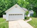 Side view of a single-story home with an attached two-car garage and a concrete driveway at 8623 Cedar Hollow Ln, Huntersville, NC 28078