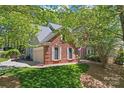 Charming brick home with a well-maintained lawn, attached garage, and lush trees providing shade and privacy at 15744 Berryfield St, Huntersville, NC 28078