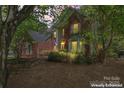 Beautiful two-story brick and gray home with decorative windows, surrounded by lush trees in a serene setting at 15744 Berryfield St, Huntersville, NC 28078