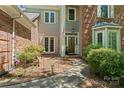 Inviting front entrance with brick and gray facade, beautiful door, and well-manicured landscaping enhancing curb appeal at 15744 Berryfield St, Huntersville, NC 28078