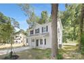 Two-story home with white siding, dark shutters, and a well-maintained lawn surrounded by mature trees at 1811 Wildwood Dr, Charlotte, NC 28214