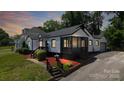 Beautifully landscaped exterior of home with green grass, mulch accents and an inviting black and white color scheme at 2138 Revolution Park Dr, Charlotte, NC 28208