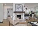Living room features an accent fireplace, wood flooring and is open to the kitchen with barstool seating at 2138 Revolution Park Dr, Charlotte, NC 28208
