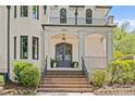 Elegant home entrance with brick steps leading to a covered porch and sophisticated gray double doors at 2200 Hastings Dr, Charlotte, NC 28207