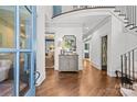 Bright foyer featuring hardwood floors, a curved staircase, and stylish console table with decorative accents at 2200 Hastings Dr, Charlotte, NC 28207