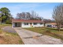 Exterior view of a well-maintained single-story home, featuring a covered carport and long driveway at 2232 Glenraven Ave, Gastonia, NC 28052