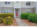 Charming front entrance with landscaped bushes and a red door at 2388 Loch Stone Dr # E, Gastonia, NC 28054