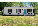 Charming home featuring a newly painted exterior, black shutters, and a vibrant turquoise front door at 2515 Danforth Ln, Charlotte, NC 28208