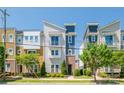 Striking three-story townhome showcasing modern design, a small balcony, and lush landscaping at 2551 Statesville Ave, Charlotte, NC 28206