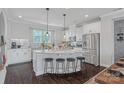 Well-lit kitchen featuring an island with barstool seating, granite countertops and stainless steel appliances at 2551 Statesville Ave, Charlotte, NC 28206