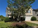 Charming home exterior features a two-car garage, lush green lawn, and a mature shade tree at 2815 Cartesian Dr, Charlotte, NC 28214