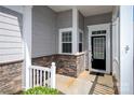 Covered front porch showcasing stone accents, white pillars, and a black front door at 3040 Azalea Dr, Indian Land, SC 29707
