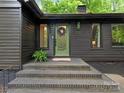 Stylish home exterior featuring a welcoming green front door and brick steps at 3232 Johnny Cake Ln, Charlotte, NC 28226