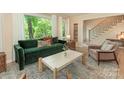 Inviting living room with a comfortable green sofa and large windows with a view at 3232 Johnny Cake Ln, Charlotte, NC 28226