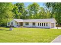 Inviting single-story home with a well-maintained lawn and an attached garage at 4307 Wrangler Sw Dr, Concord, NC 28027