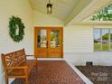 Cozy covered front porch featuring a wooden bench and double doors at 4307 Wrangler Sw Dr, Concord, NC 28027