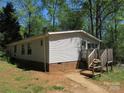Rear view of a home with brick foundation, featuring a small porch and steps leading to the backyard at 6293 Karen Dr, Claremont, NC 28610