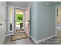 Welcoming entryway with a pink door and grey flooring, leading to the living areas at 7018 Huntsmaster Dr, Charlotte, NC 28277