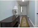 Clean hallway with sleek, grey flooring, complemented by a console table with lamp at 7018 Huntsmaster Dr, Charlotte, NC 28277