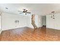 Spacious living room with wood floors, a ceiling fan and staircase leading to the upper level at 7607 Petrea Ln, Charlotte, NC 28227