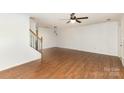 Spacious living room featuring wood floors, staircase and pendant lights at 7607 Petrea Ln, Charlotte, NC 28227