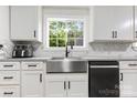 Farmhouse sink with white cabinets and stainless steel appliances under a large window at 814 Columbia Dr, Chester, SC 29706
