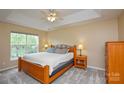 Cozy bedroom featuring a king-size bed, tray ceiling, and natural light from a large window at 9713 Autumn Applause Dr, Charlotte, NC 28277