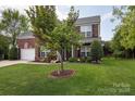 Lovely two-story brick home with a well-kept lawn and mature tree, showcasing curb appeal at 1002 Banaba Dr, Indian Trail, NC 28079