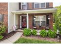 Inviting front porch with cozy seating, decorative plants, and a welcoming entrance with sidelight windows at 1002 Banaba Dr, Indian Trail, NC 28079