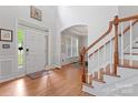 Grand foyer with hardwood floors, staircase, soaring ceilings, and abundant natural light streaming through the windows at 1009 Anduin Falls Dr, Charlotte, NC 28269