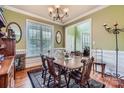 Inviting dining room featuring hardwood floors, a chandelier, and a large window with natural light at 10836 Maryanna Ct, Charlotte, NC 28213