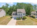 Inviting two-story home with lush green lawn, a two-car garage, and column-supported porch at 112 Serravista St, Mooresville, NC 28117
