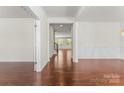 Inviting hallway with gleaming wood floors, white trim, and views into other rooms, creating a sense of spaciousness at 112 Serravista St, Mooresville, NC 28117
