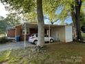 Carport with a car parked, attached storage room, and view of the brick home, providing sheltered parking at 1218 Forestdale Dr, Salisbury, NC 28144