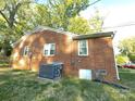 Exterior view of a brick home showing the utility connections, AC unit, and a partially visible red car at 1218 Forestdale Dr, Salisbury, NC 28144