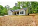 Exterior view of single-story home with white siding, black roof, attached garage, and wooded surroundings at 164 Hillndale Ln, Statesville, NC 28677