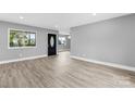Spacious living room featuring modern wood flooring, fresh gray paint, and natural lighting at 2019 Kingston Rd, Kingstown, NC 28150
