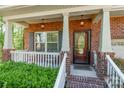 Inviting front porch with brick columns, a white railing, and a cozy welcome mat at 2202 Chickasaw Loop, Rock Hill, SC 29732
