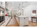Modern kitchen features white cabinets, stainless steel appliances, a spacious island, and hardwood floors at 2558 Deacon Ave, Charlotte, NC 28204