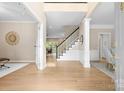 Open foyer boasts hardwood floors, staircase with black railings, and views into adjacent living spaces at 2710 Providence Spring Ln, Charlotte, NC 28270