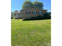 Large, verdant backyard showcasing the property's exterior with brick and siding at 28344 Canton Rd, Albemarle, NC 28001