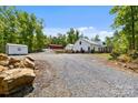 Long gravel driveway leading to a beautifully maintained farmhouse with a barn and storage building at 29268 Pennington Rd, Albemarle, NC 28001