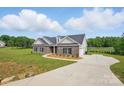 Stunning home with a long driveway and lush green lawn offers ample space and curb appeal at 3013 Isle Ln, Monroe, NC 28110