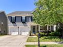 Beautiful two-story home with a three-car garage, covered front porch and immaculate landscaping at 3057 Drummond Ave, Indian Land, SC 29707