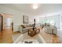Open-concept living room with hardwood floors connecting to the dining area at 3233 Sunnymede Ln, Charlotte, NC 28209