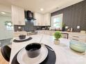 Stylish kitchen with white cabinets, a marble countertop, and a backsplash arranged in a herringbone pattern at 3317 Sargeant Dr, Charlotte, NC 28217